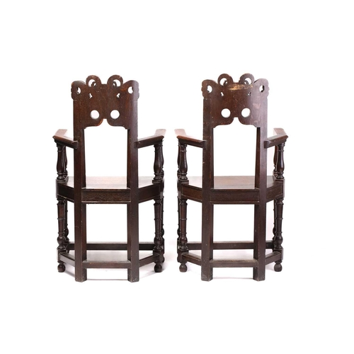 344 - A pair of French carved oak caquetoire armchairs, 19th/20th century, the curved backs carved and pie... 