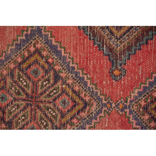 366 - A Hamadan red ground strip runner, with nine lozenges on a central pole within a stylized border. 30... 