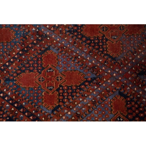 367 - A large brick red/brown ground Qashqai rug with blue St. Andrew's cross filled diamond pattern withi... 