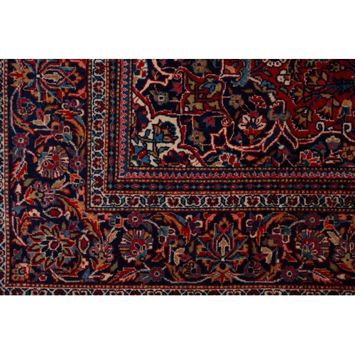 371 - A Kashan rug, with central mandorla and lanterns on a red ground, within palmette borders 202cm x 13... 