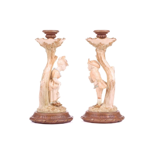 403 - A pair of Royal Worcester figural candlesticks, modelled by James Hadley, as a boy and girl in fine ... 