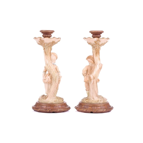 403 - A pair of Royal Worcester figural candlesticks, modelled by James Hadley, as a boy and girl in fine ... 