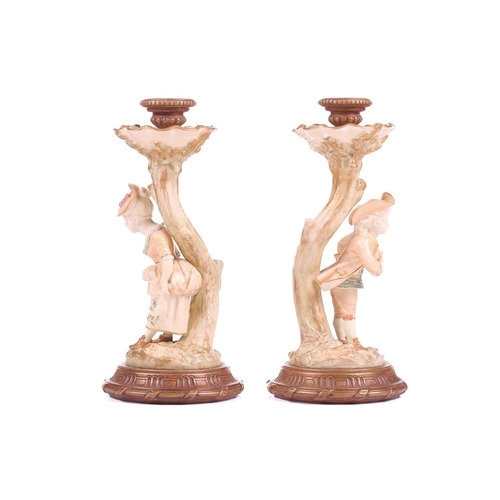 403 - A pair of Royal Worcester figural candlesticks, modelled by James Hadley, as a boy and girl in fine ... 