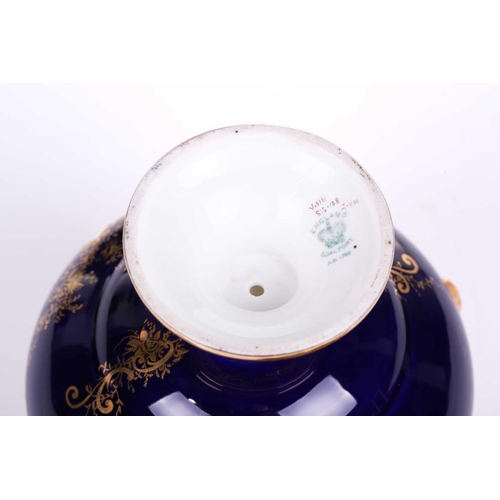 404 - A Coalport Bleu de Roi porcelain two-handled globular urn and cover hand painted with romantic lands... 