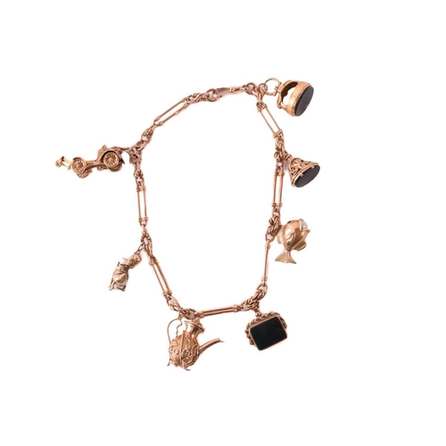 62 - A 9ct rose gold watch chain with charms, comprising a trombone link chain terminated with a swivel c... 