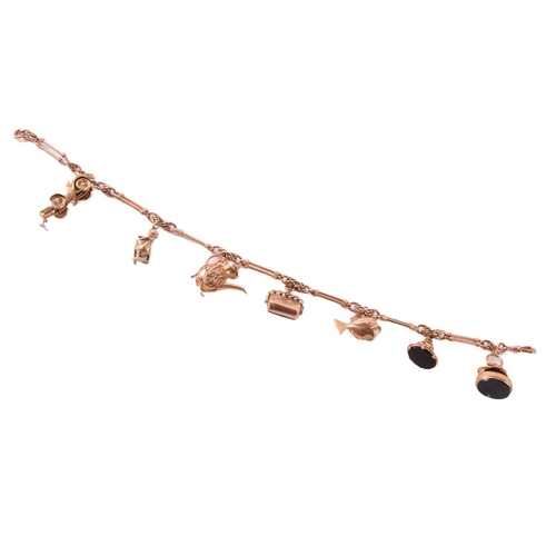 62 - A 9ct rose gold watch chain with charms, comprising a trombone link chain terminated with a swivel c... 