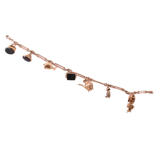 62 - A 9ct rose gold watch chain with charms, comprising a trombone link chain terminated with a swivel c... 