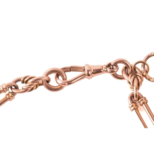 62 - A 9ct rose gold watch chain with charms, comprising a trombone link chain terminated with a swivel c... 