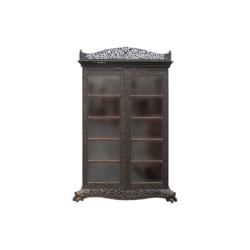 133 - A 19th-century well-carved Anglo Indian rosewood/padauk wood two-door bookcase, c.1850s, with pierce... 