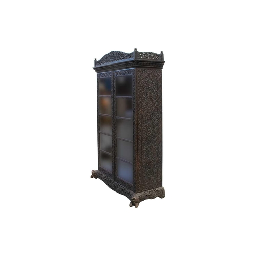 133 - A 19th-century well-carved Anglo Indian rosewood/padauk wood two-door bookcase, c.1850s, with pierce... 