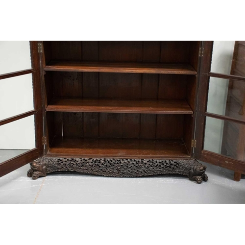 133 - A 19th-century well-carved Anglo Indian rosewood/padauk wood two-door bookcase, c.1850s, with pierce... 