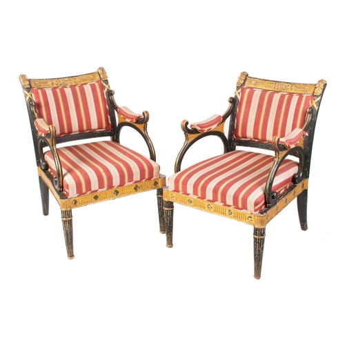 145 - A pair of Regency and later painted and parcel gilt library armchairs with floral carved cresting ra... 