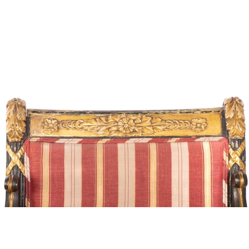 145 - A pair of Regency and later painted and parcel gilt library armchairs with floral carved cresting ra... 