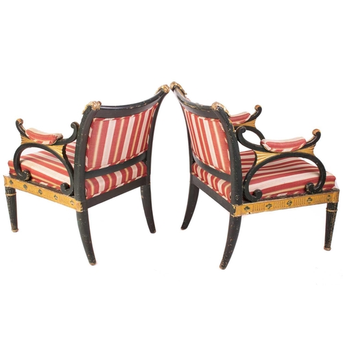145 - A pair of Regency and later painted and parcel gilt library armchairs with floral carved cresting ra... 
