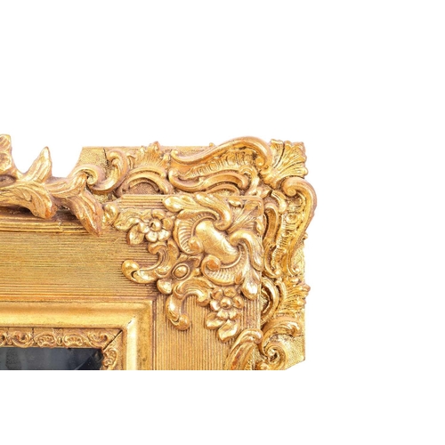151 - A 19th-century moulded and gilt plaster mirror with bevelled glass, the crest with a bird amongst ro... 
