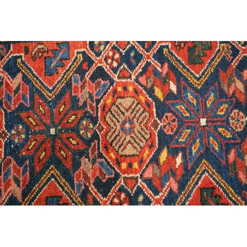 152 - An antique Hammadan runner with a central star lozenge pole on a blue ground within multiple borders... 