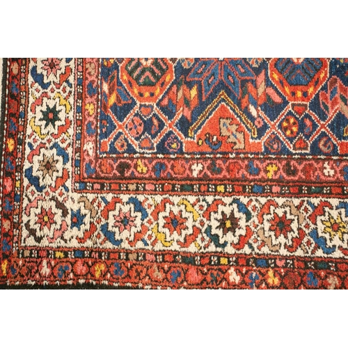 152 - An antique Hammadan runner with a central star lozenge pole on a blue ground within multiple borders... 