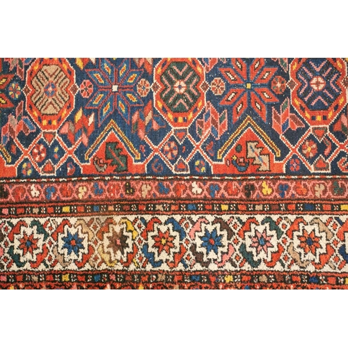 152 - An antique Hammadan runner with a central star lozenge pole on a blue ground within multiple borders... 