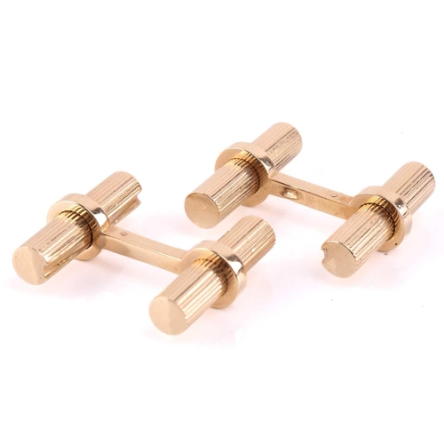11 - A pair of cufflinks in the style of Cartier; the yellow metal baton links, fluted and held in place ... 