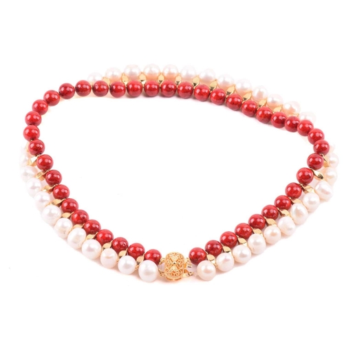 134 - A cultured pearl and dyed red howlite suite of jewellery, comprising necklace, bracelet and earrings... 