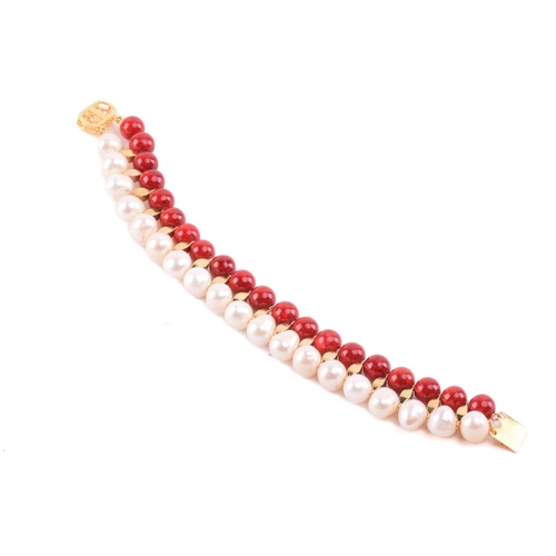 134 - A cultured pearl and dyed red howlite suite of jewellery, comprising necklace, bracelet and earrings... 