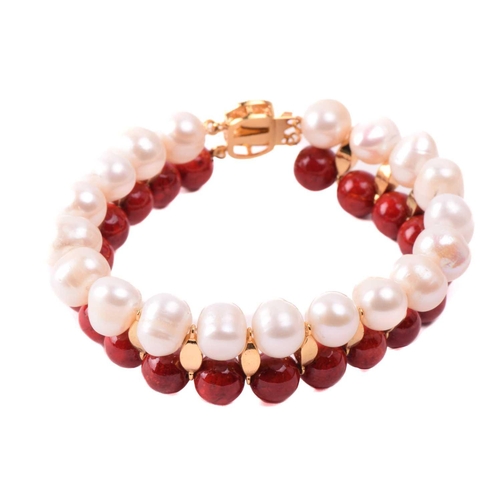 134 - A cultured pearl and dyed red howlite suite of jewellery, comprising necklace, bracelet and earrings... 