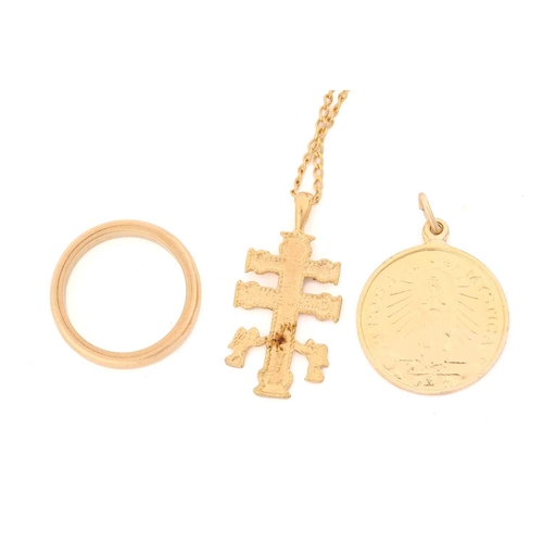 140 - An 18ct gold wedding band together with two religious pendants and a chain. The 18ct wedding ring me... 