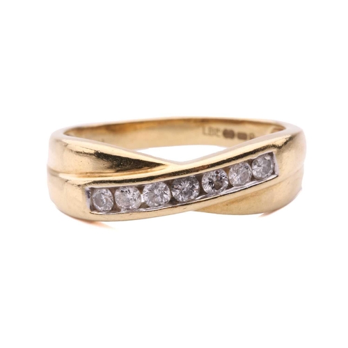 157 - A seven stone diamond cross over ring, set with a row of round brilliant cut diamonds, with a total ... 