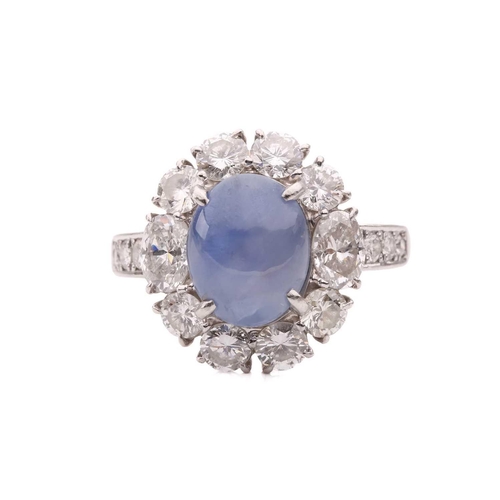 158 - A star sapphire and diamond entourage ring, centred with a star sapphire of 9.7 x 7.7 x 6.0 mm, with... 