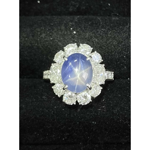 158 - A star sapphire and diamond entourage ring, centred with a star sapphire of 9.7 x 7.7 x 6.0 mm, with... 