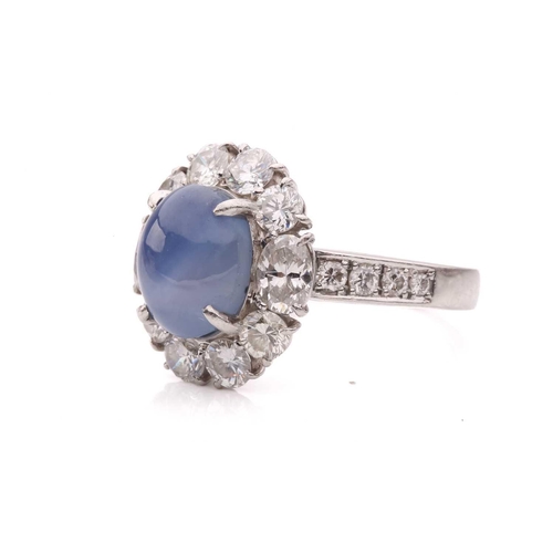158 - A star sapphire and diamond entourage ring, centred with a star sapphire of 9.7 x 7.7 x 6.0 mm, with... 
