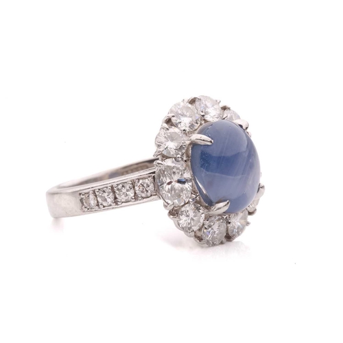158 - A star sapphire and diamond entourage ring, centred with a star sapphire of 9.7 x 7.7 x 6.0 mm, with... 
