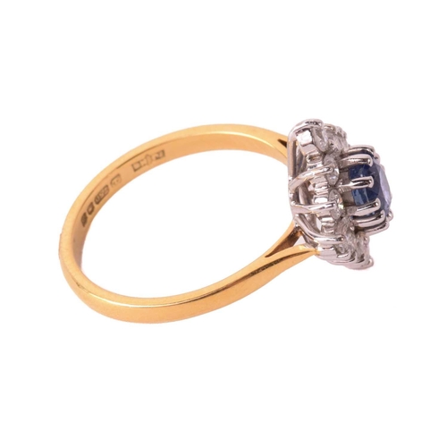 162 - A sapphire and diamond cluster ring, the central sapphire measuring 5.4mm x 4.5mm x 3.6mm, surrounde... 