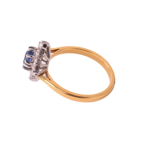 162 - A sapphire and diamond cluster ring, the central sapphire measuring 5.4mm x 4.5mm x 3.6mm, surrounde... 