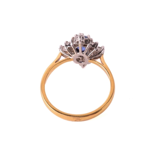 162 - A sapphire and diamond cluster ring, the central sapphire measuring 5.4mm x 4.5mm x 3.6mm, surrounde... 
