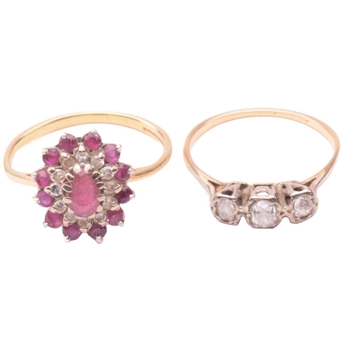 164 - A three stone diamond ring together with a ruby and diamond cluster ring; the first set with a trio ... 