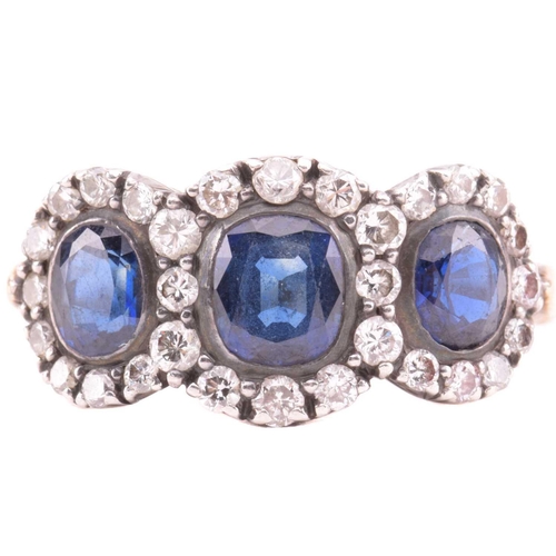 166 - A sapphire and diamond triple cluster ring, the central cushion shape sapphire measuring 5.7mm x 5mm... 
