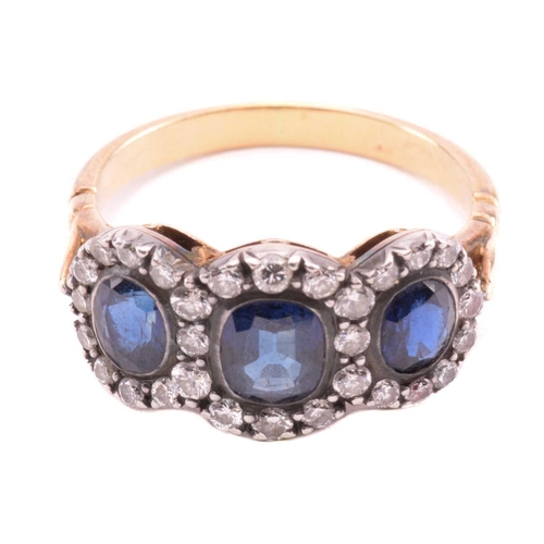 166 - A sapphire and diamond triple cluster ring, the central cushion shape sapphire measuring 5.7mm x 5mm... 