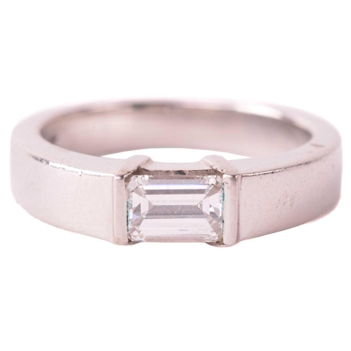 175 - A solitaire diamond ring, set with an emerald cut diamond with an estimated weight of 0.50ct, betwee... 