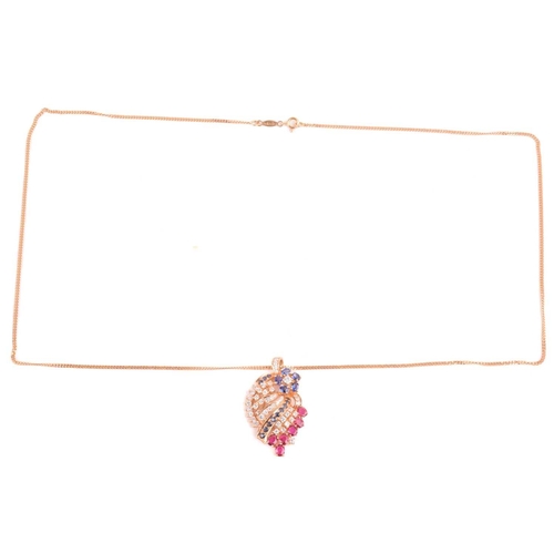 25 - A diamond, ruby and sapphire spray pendant on chain; the stylised spray comprising a six stone sapph... 
