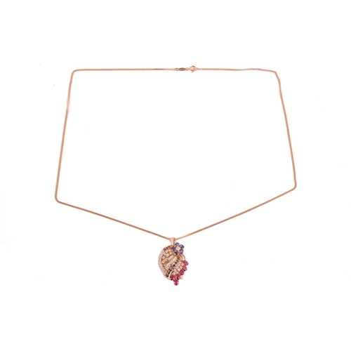 25 - A diamond, ruby and sapphire spray pendant on chain; the stylised spray comprising a six stone sapph... 