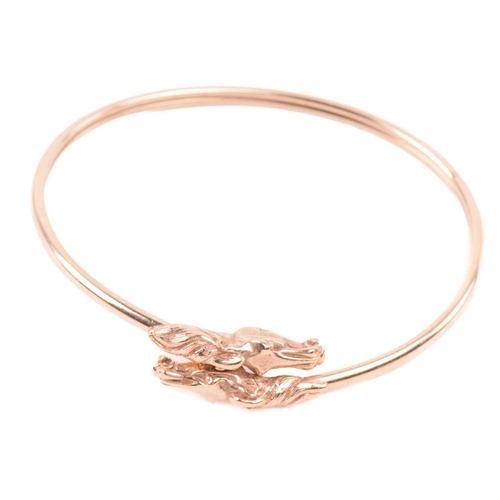 254 - A double horse head torque bangle, with a double hollow tube construction, designed to flex open wit... 
