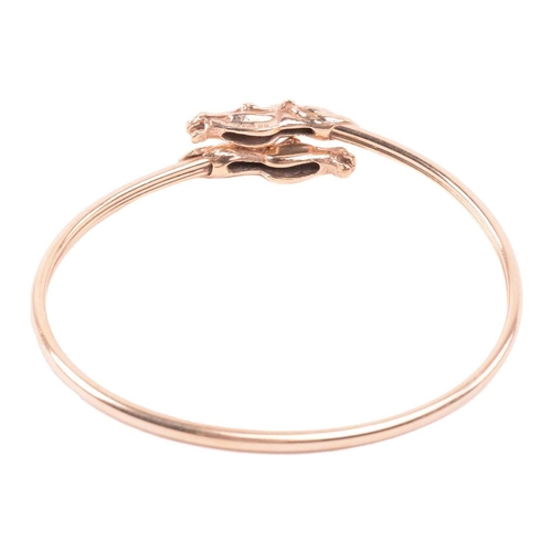 254 - A double horse head torque bangle, with a double hollow tube construction, designed to flex open wit... 