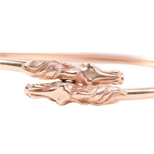 254 - A double horse head torque bangle, with a double hollow tube construction, designed to flex open wit... 