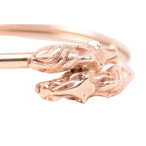 254 - A double horse head torque bangle, with a double hollow tube construction, designed to flex open wit... 