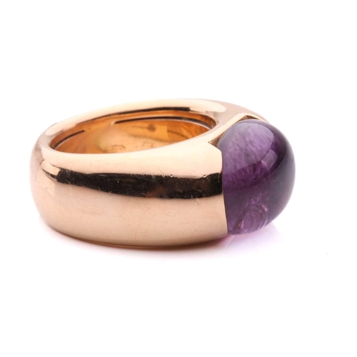 258 - An amethyst cocktail ring by Adolfo Courrier, centred with an oval amethyst cabochon in a closed-bac... 