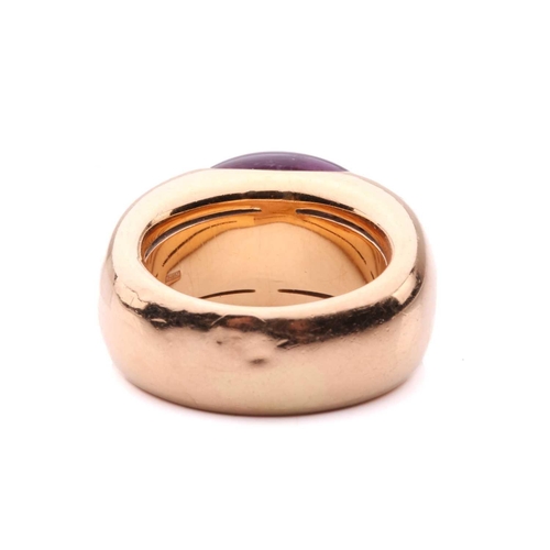 258 - An amethyst cocktail ring by Adolfo Courrier, centred with an oval amethyst cabochon in a closed-bac... 