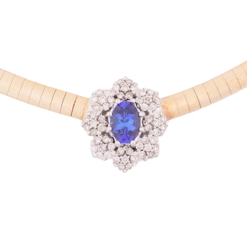 26 - A tanzanite and diamond cluster necklace, centred with an oval-cut tanzanite of 7.1 x 5.1 mm, within... 