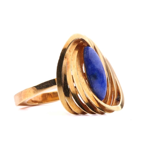 267 - A Modernist lapis lazuli cocktail ring in 18ct gold, composed of interlocking polished oval rings, c... 