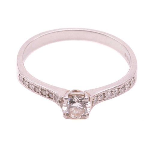 27 - A single stone diamond ring, the round brilliant cut diamond in simple four claw mount, with diamond... 